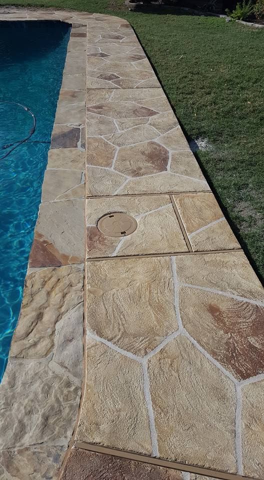 A stone walkway leading to a swimming pool.