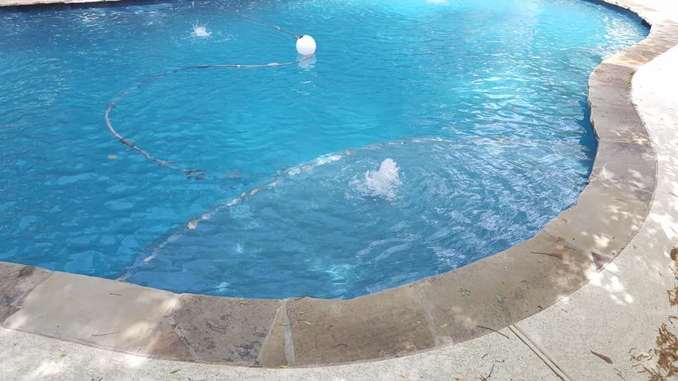 A large swimming pool with a fountain in the middle of it.