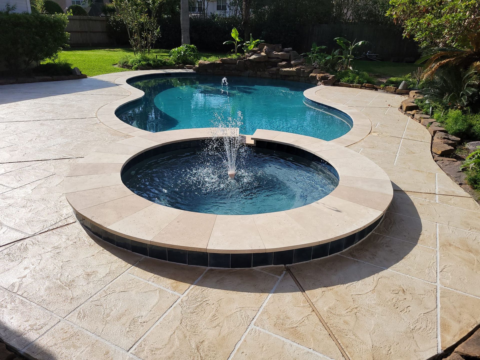 A swimming pool with a fountain in the middle of it