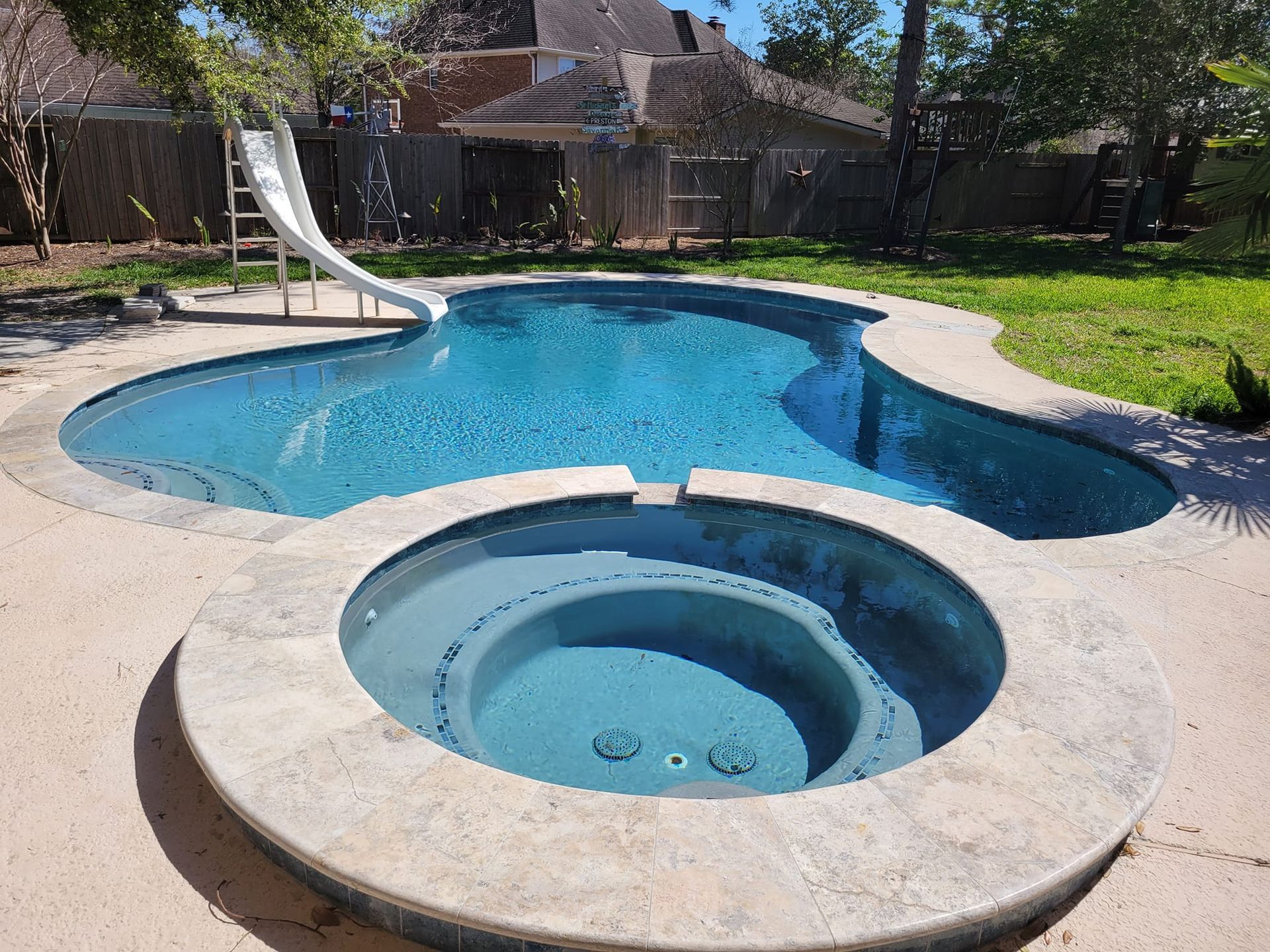 A swimming pool with a slide and a hot tub