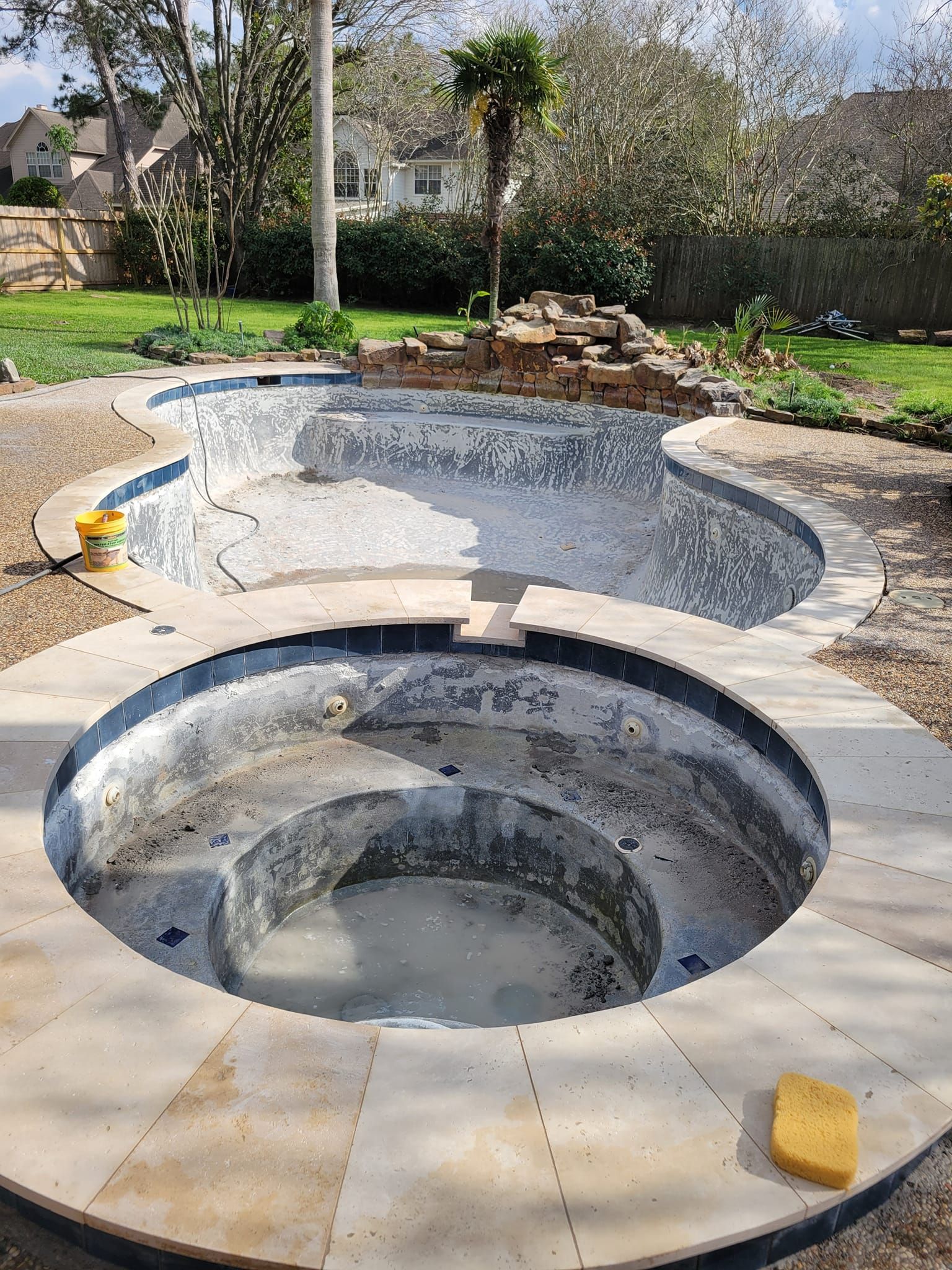 A swimming pool and a hot tub are being built in a backyard.