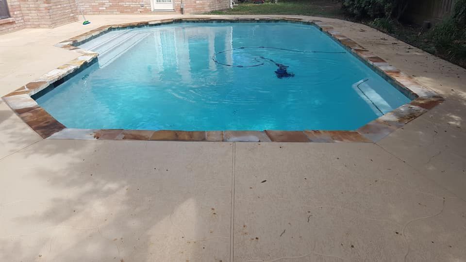 A large swimming pool is sitting on top of a concrete patio.