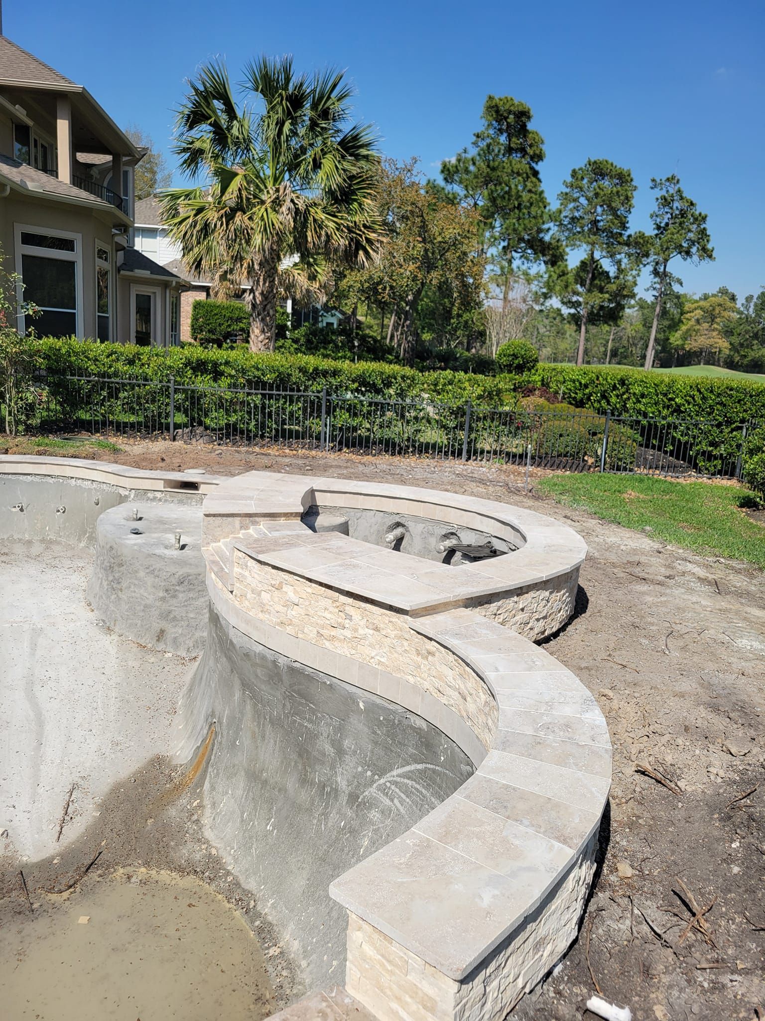 A swimming pool is being built in the backyard of a house.