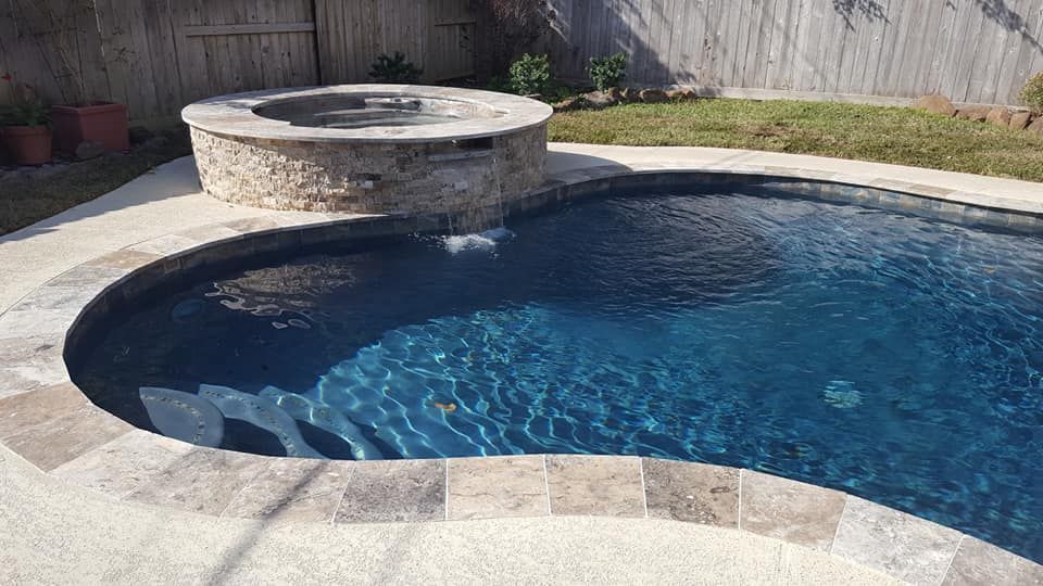 A swimming pool with a hot tub in the middle of it