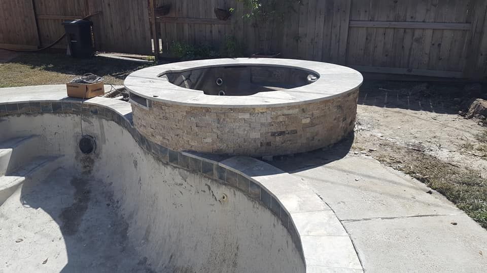 A swimming pool with a fire pit in the middle of it.