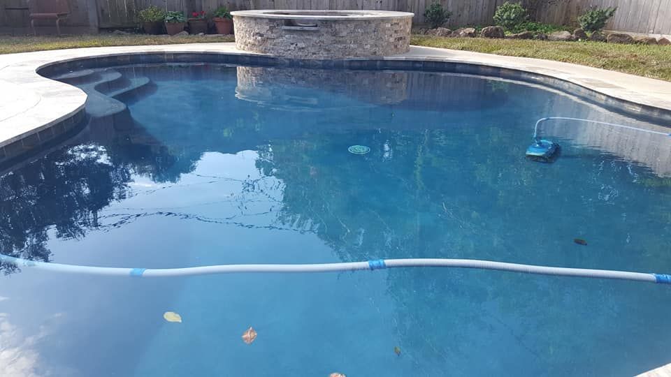 A large swimming pool with a vacuum cleaner in it.