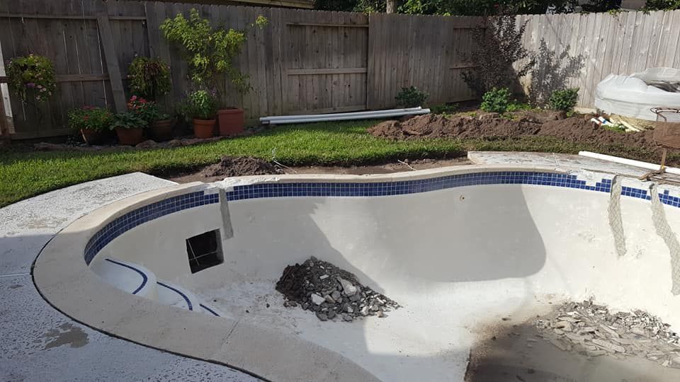 A swimming pool is being remodeled in a backyard.