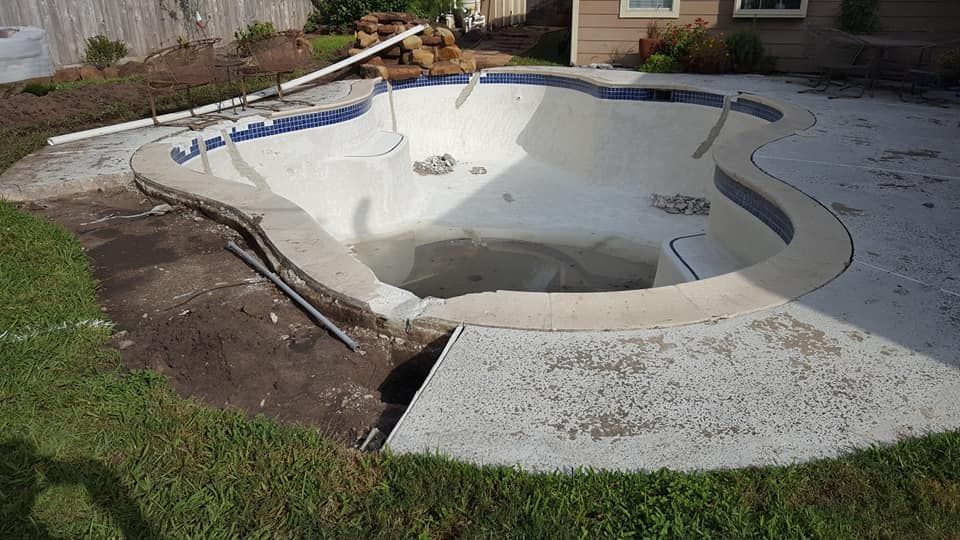 A swimming pool is being remodeled in a backyard.