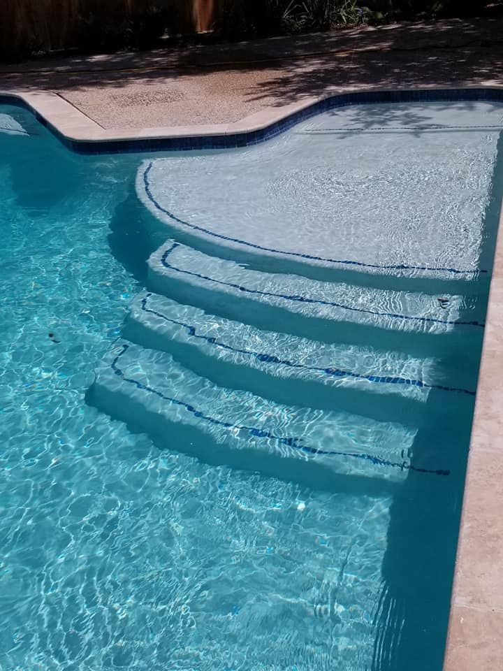 A swimming pool with stairs leading up to it