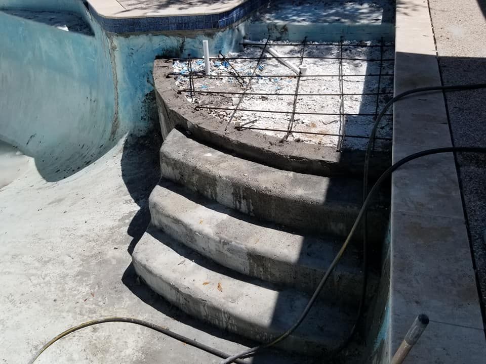 A concrete staircase is being built next to a pool