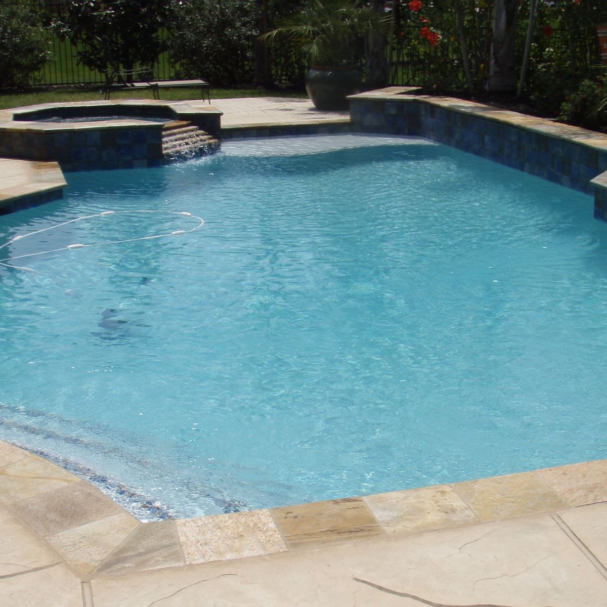 A large swimming pool with a waterfall in the middle