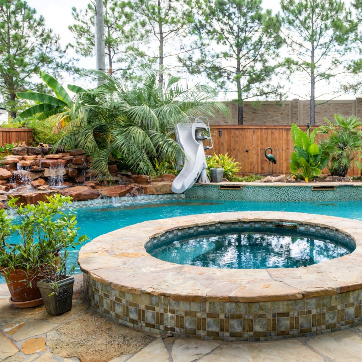 A swimming pool with a hot tub and a slide