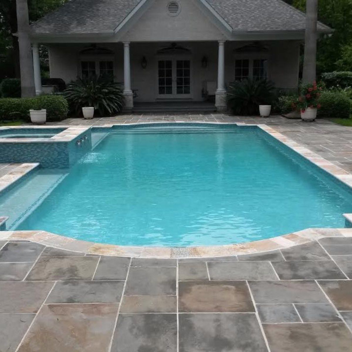 A large swimming pool in front of a house