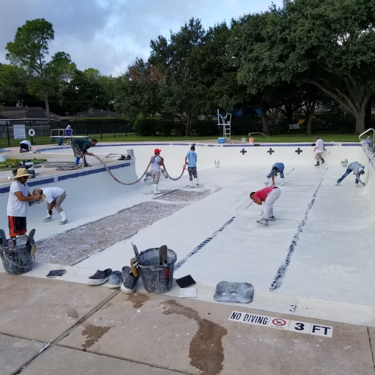 A group of people are working on a swimming pool that is 3 ft deep