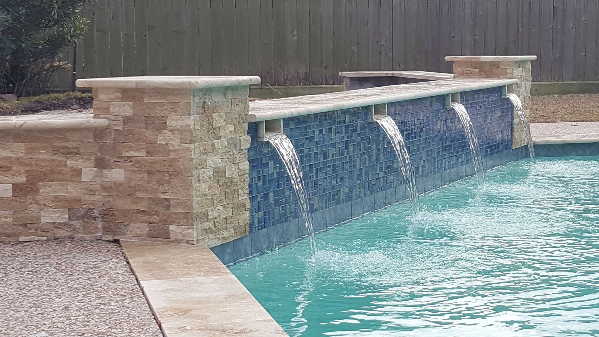 There is a waterfall in the middle of the pool.
