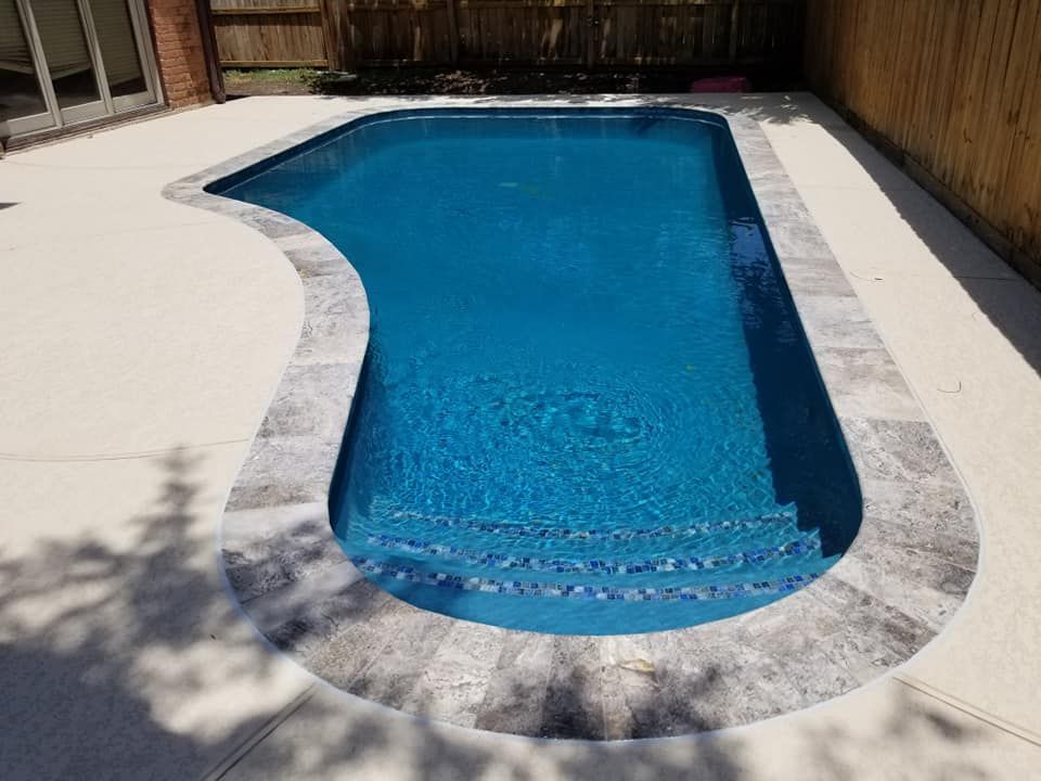 A large blue swimming pool is sitting on top of a concrete patio.