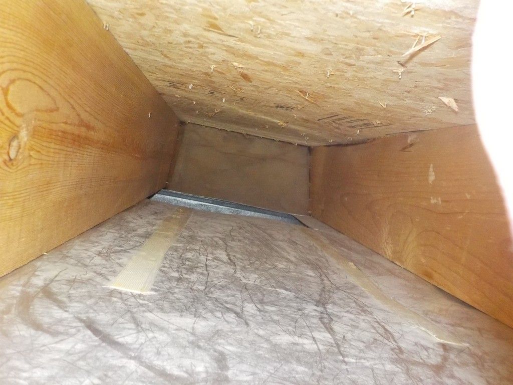 The inside of a wooden box with a hole in the middle.