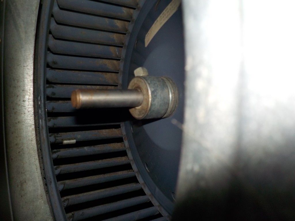 A close up of a fan with a metal shaft attached to it.
