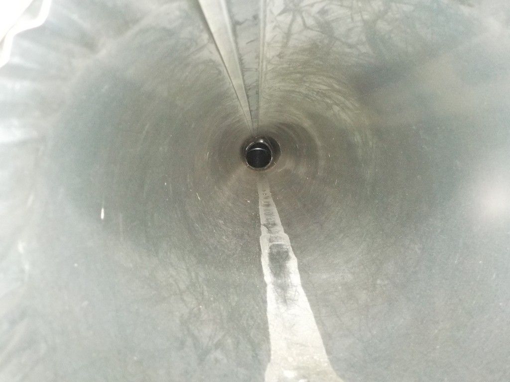 A close up of a metal pipe with a hole in the middle.
