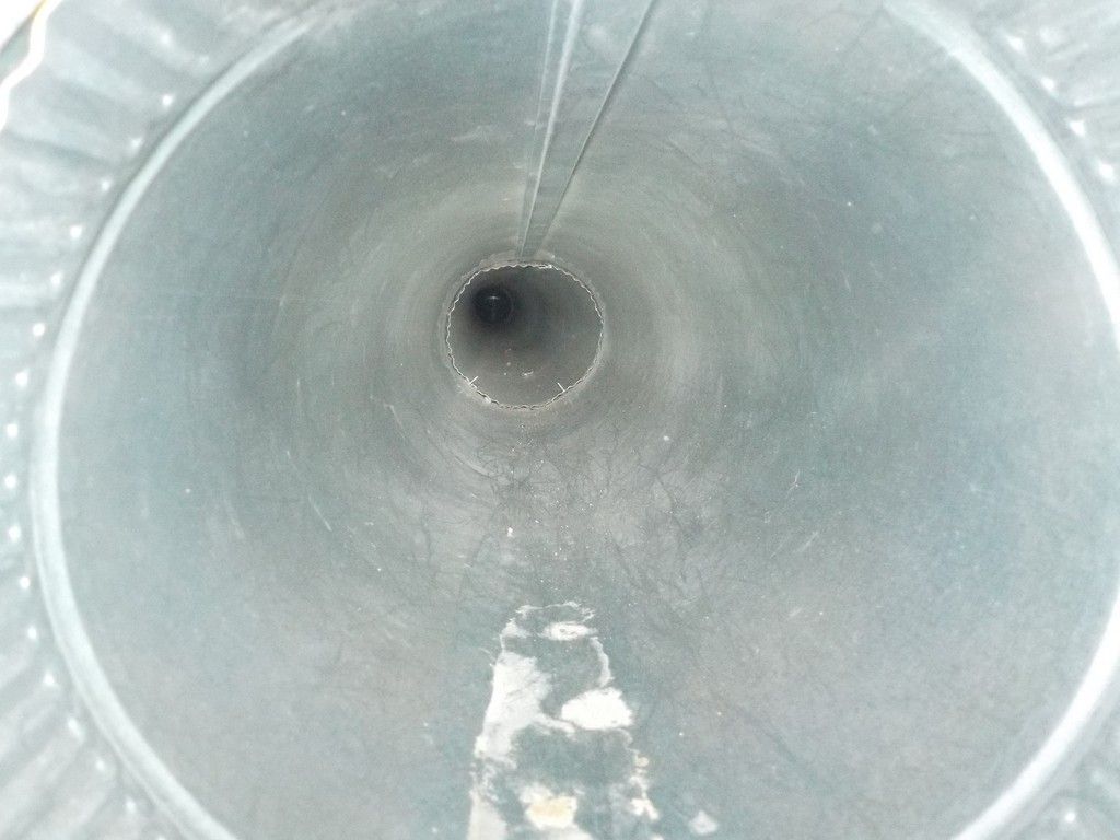 A close up of a metal pipe with a hole in the middle