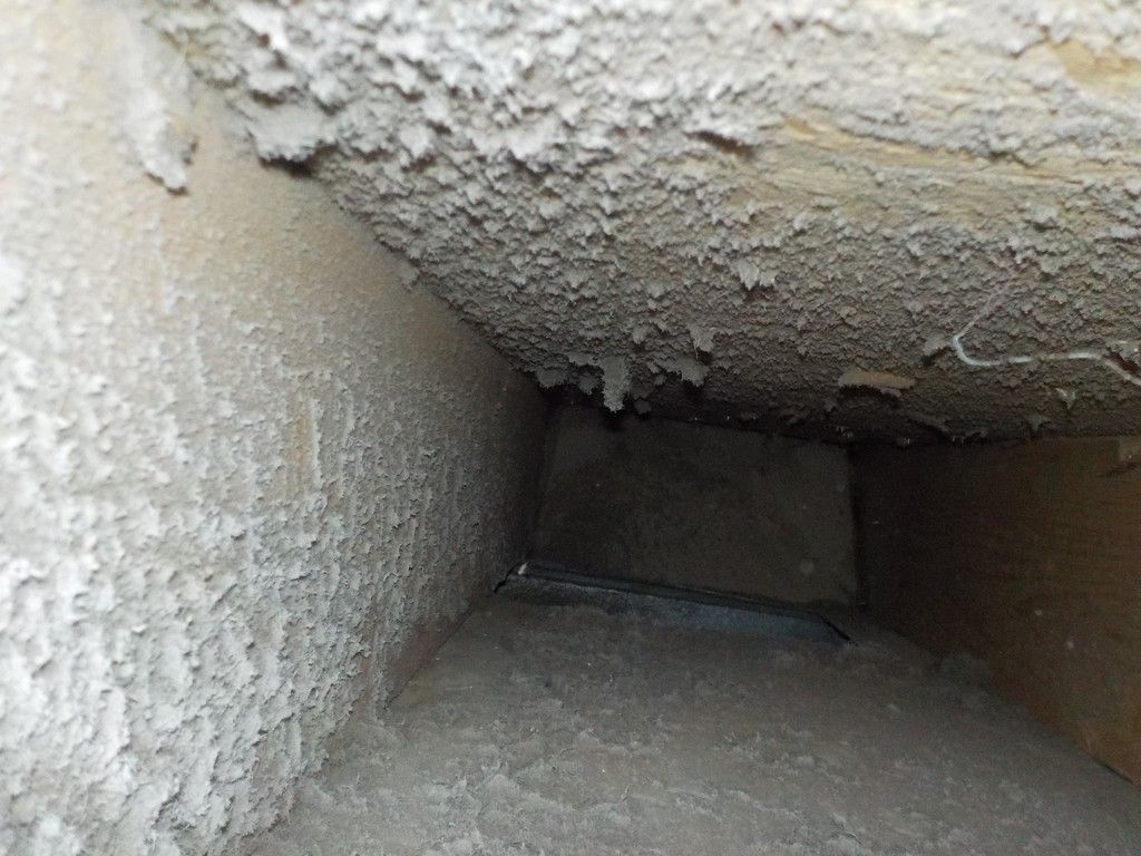 A close up of a dirty air vent in a building.