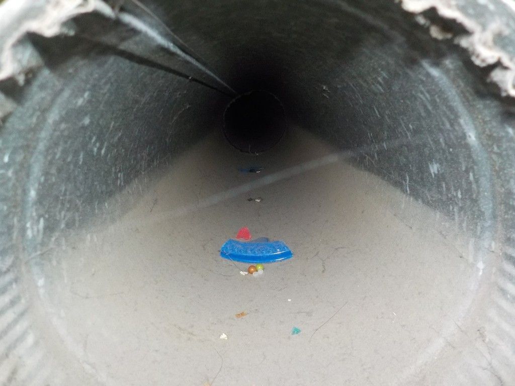 A close up of the inside of a pipe with a blue object in the middle.
