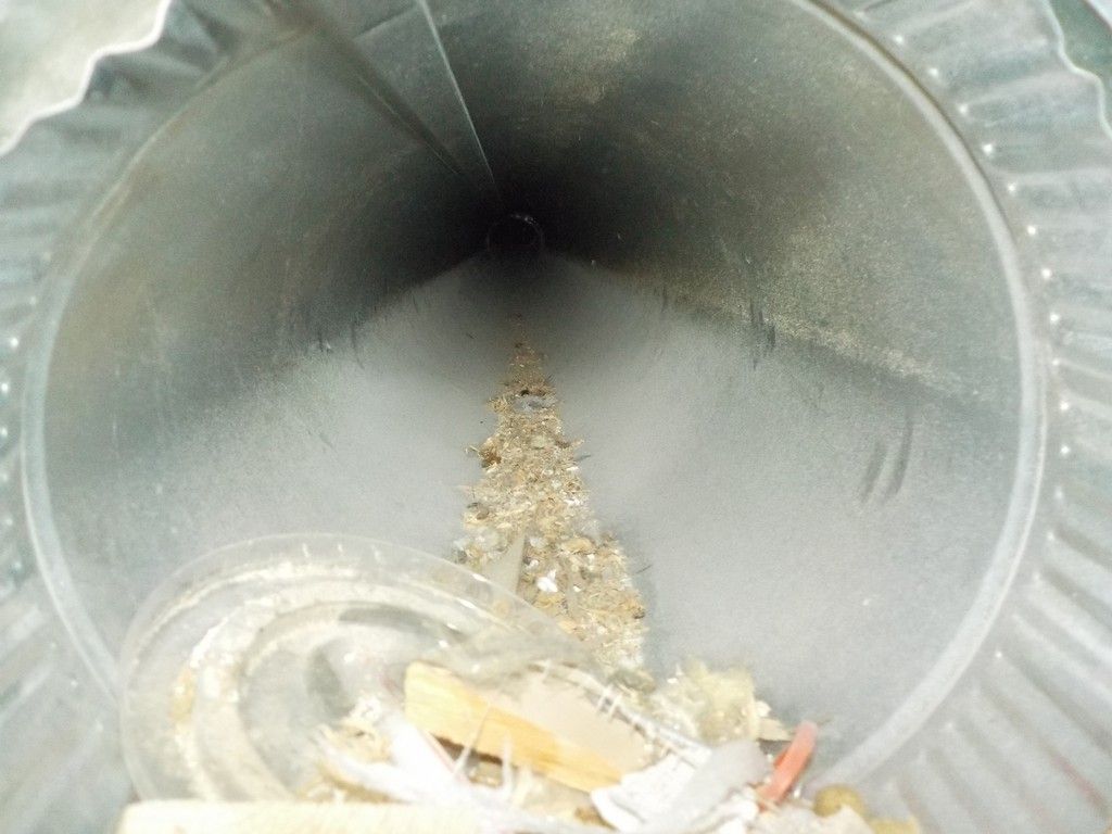 The inside of a metal trash can filled with trash