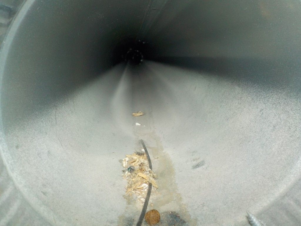 A close up of a metal pipe with water spraying out of it.