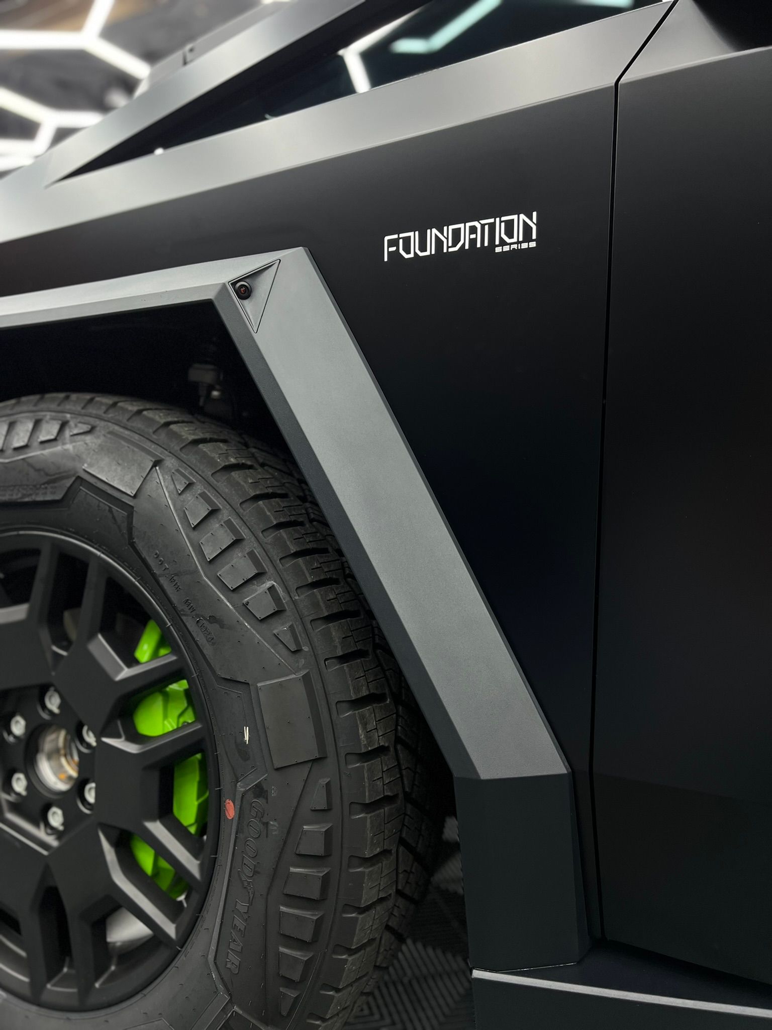 A person wearing black gloves is polishing the hood of a car.