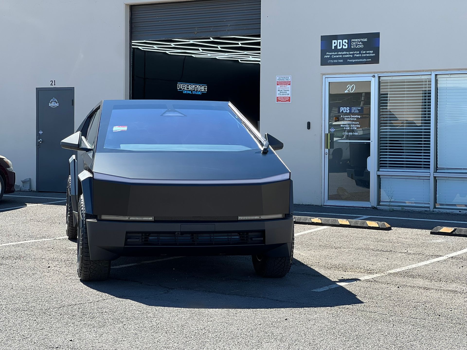 A tesla cybertruck is parked in front of a building.