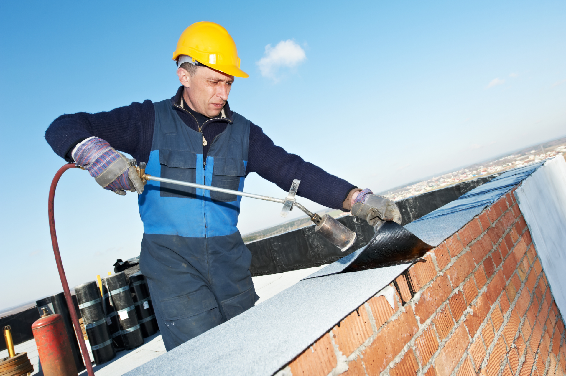 ACE employee using a blow torch to install roofing