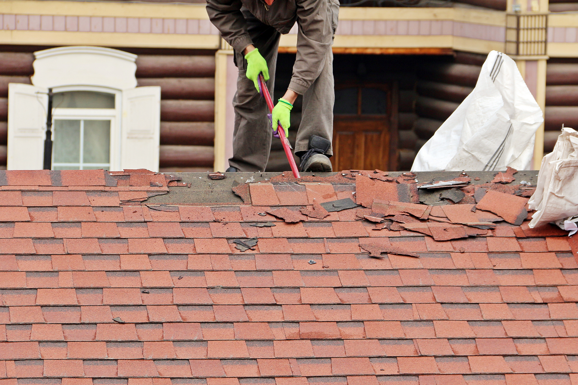 Shingle being removed from a roof to be replaced by ACE