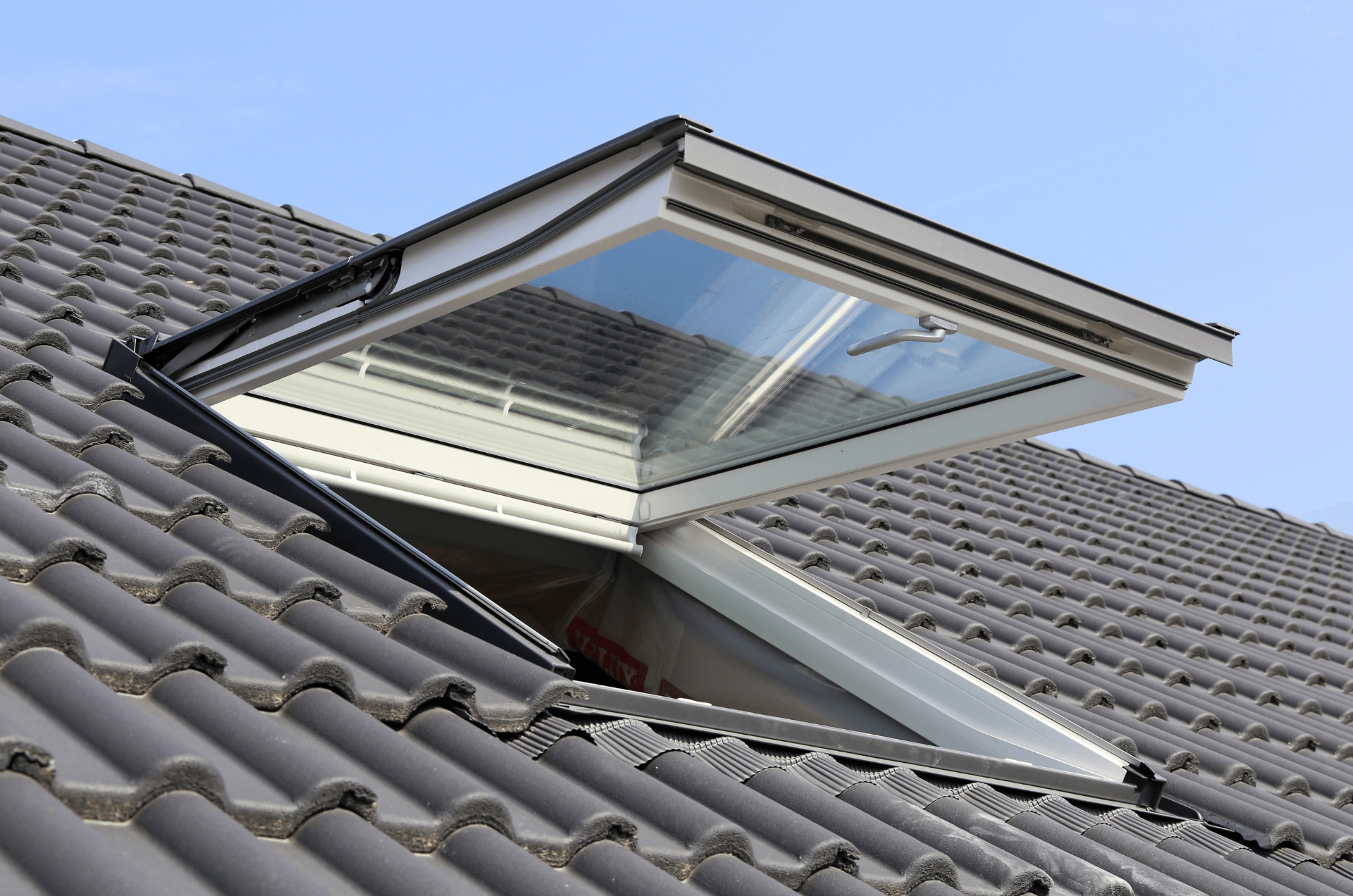 Open skylight window shown from the outside on the roof of a residential property