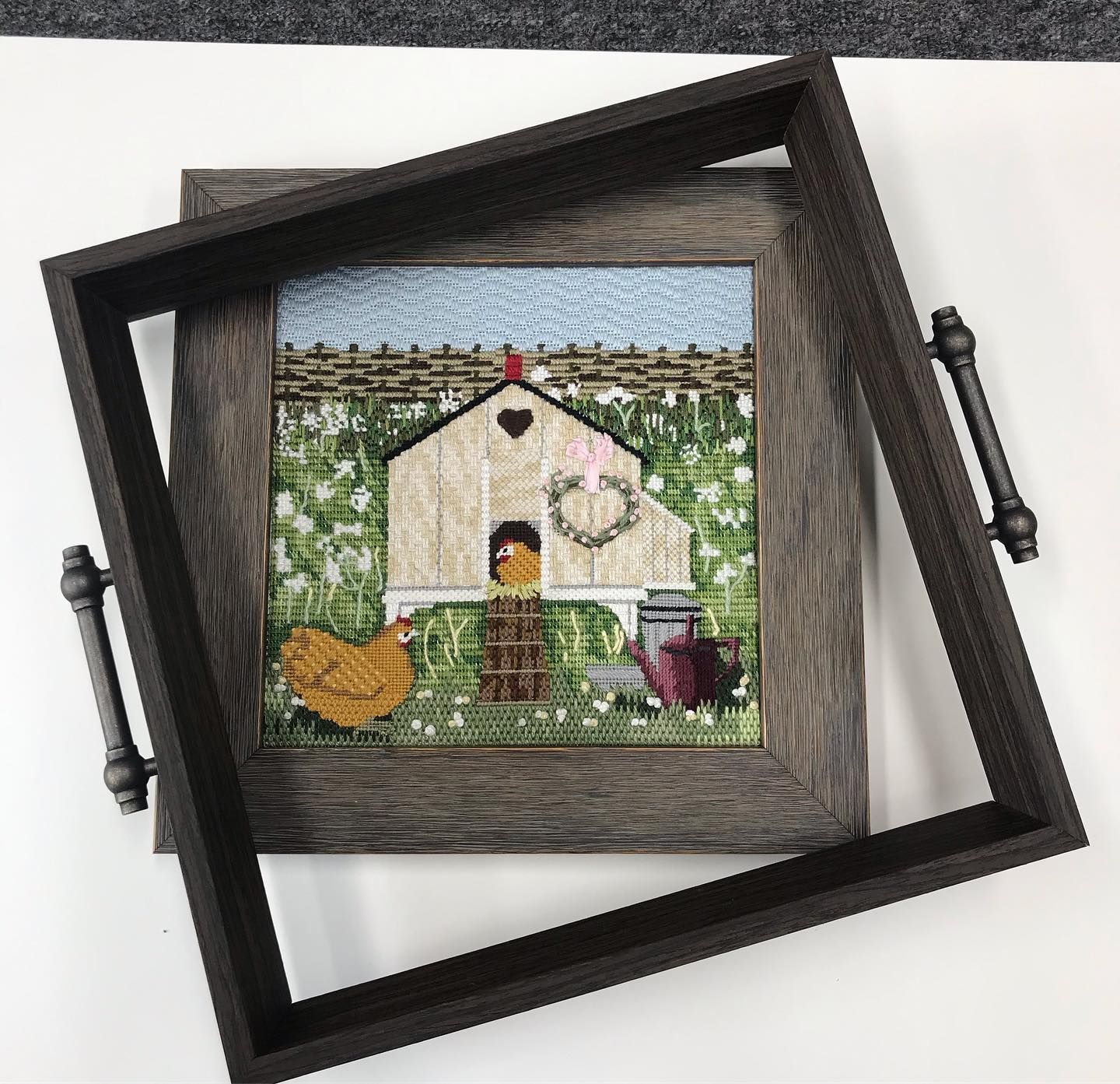 Square tray with chicken coop art, wooden frame, dark handles.
