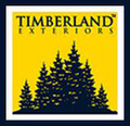 The logo for timberland exteriors shows a group of pine trees on a yellow background.