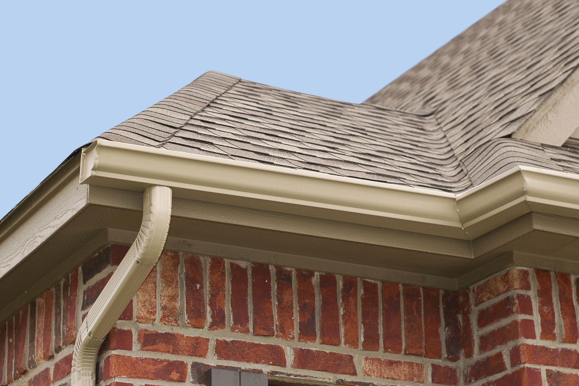 A brick house with a gutter on the side of it
