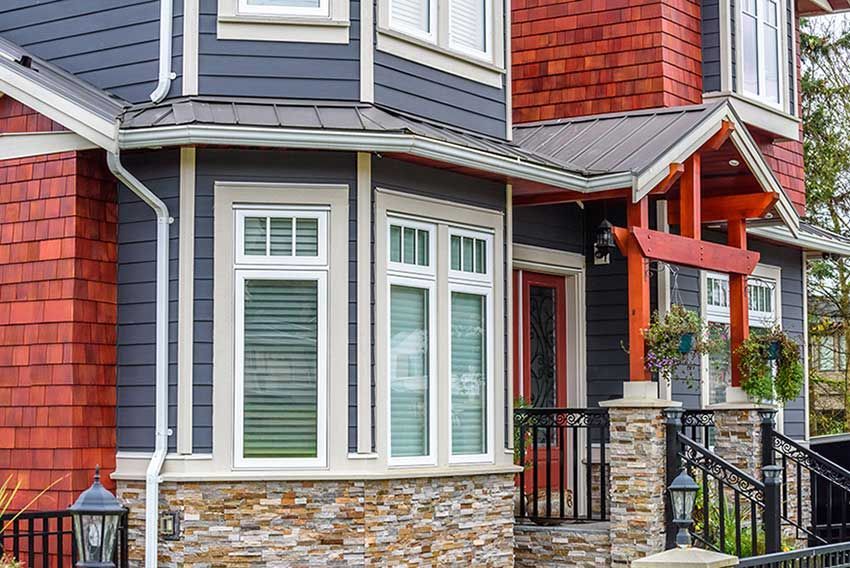 A large house with a lot of windows and a stone wall.