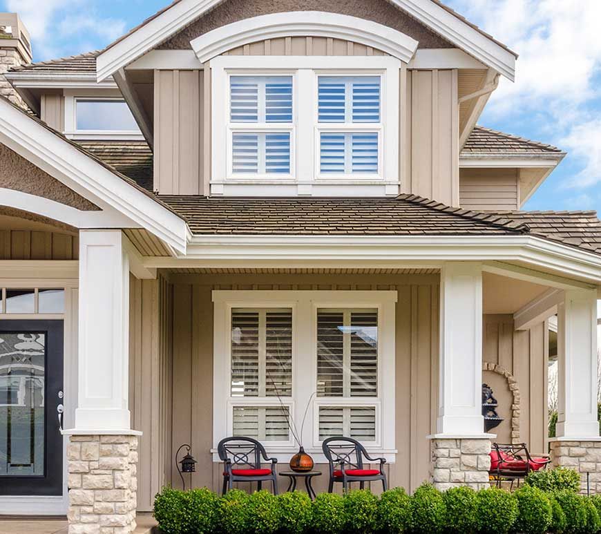 A house with a porch and chairs in front of it
