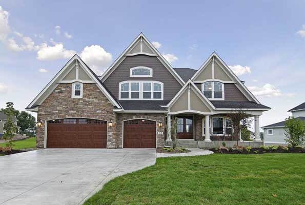 A large house with two garage doors and a concrete driveway