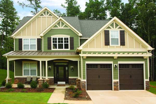 A green and tan house with two garage doors