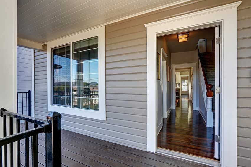 The front door of a house with a porch and stairs.