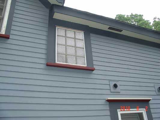 A blue house with a window on the side of it