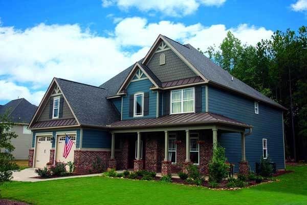 A blue house with a gray roof and a porch