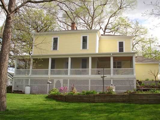A large yellow house with a large porch
