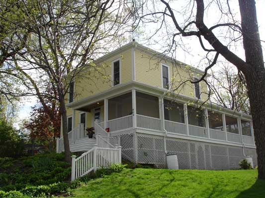 A large yellow house with a white porch and stairs