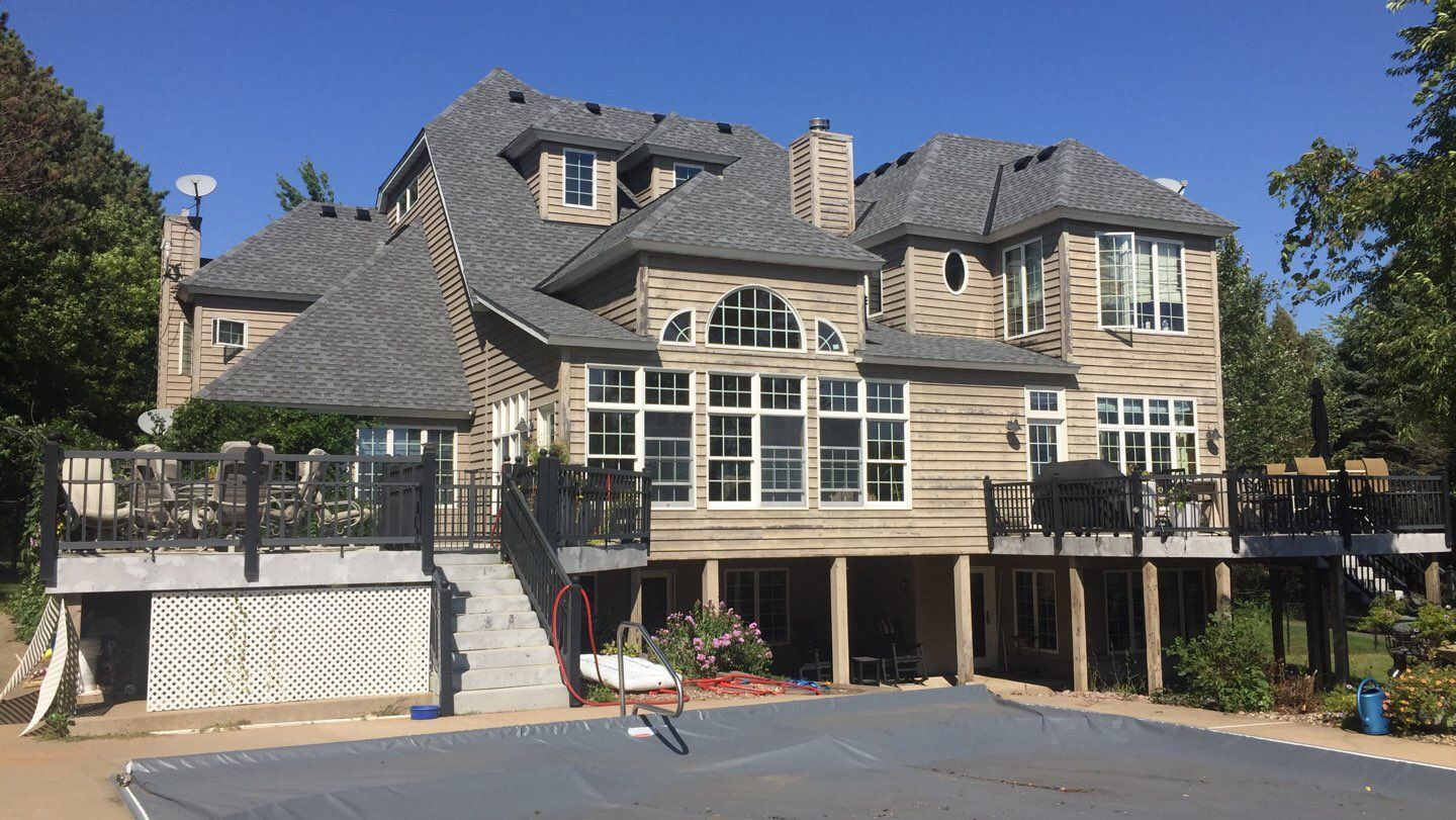A large house with a basketball court in front of it.