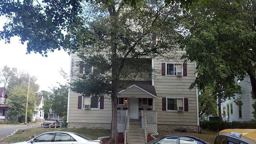 A house with two cars parked in front of it
