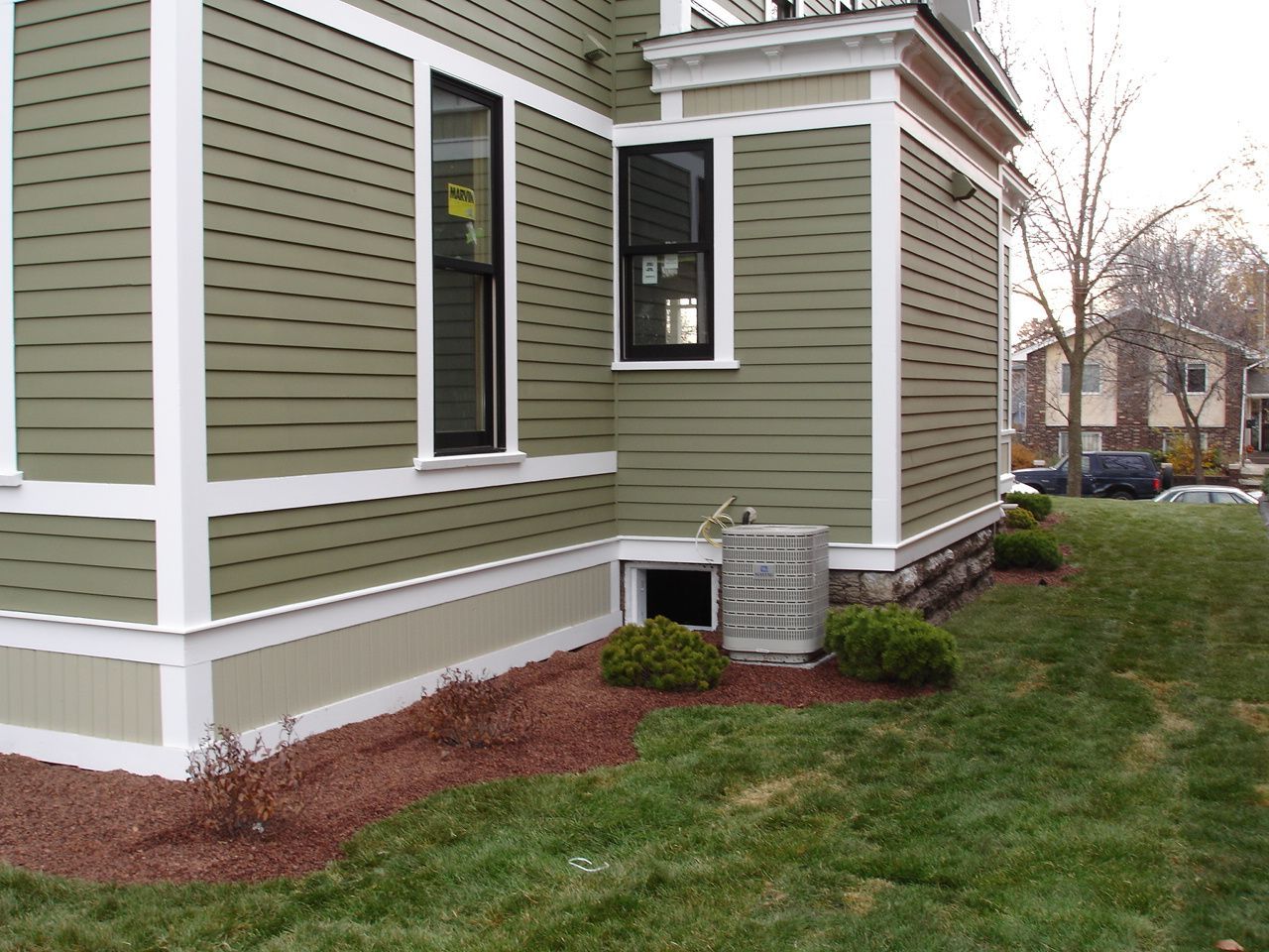 A green house with white trim and a window
