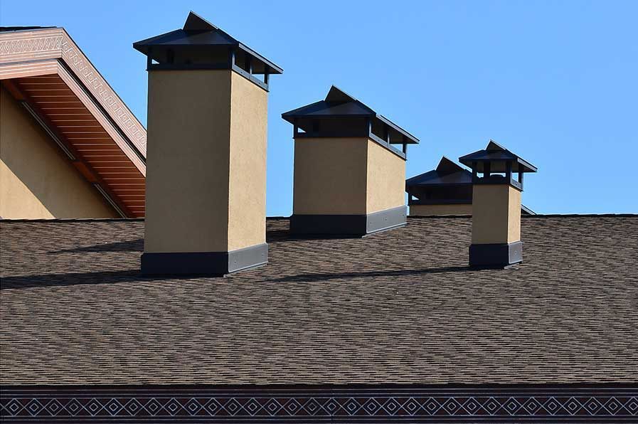 A row of chimneys on the roof of a house.