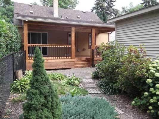 A house with a porch and a fence in the backyard